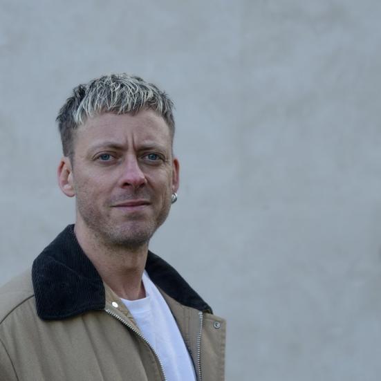 Forfatteren Theis Ørntoft foran en grå mur