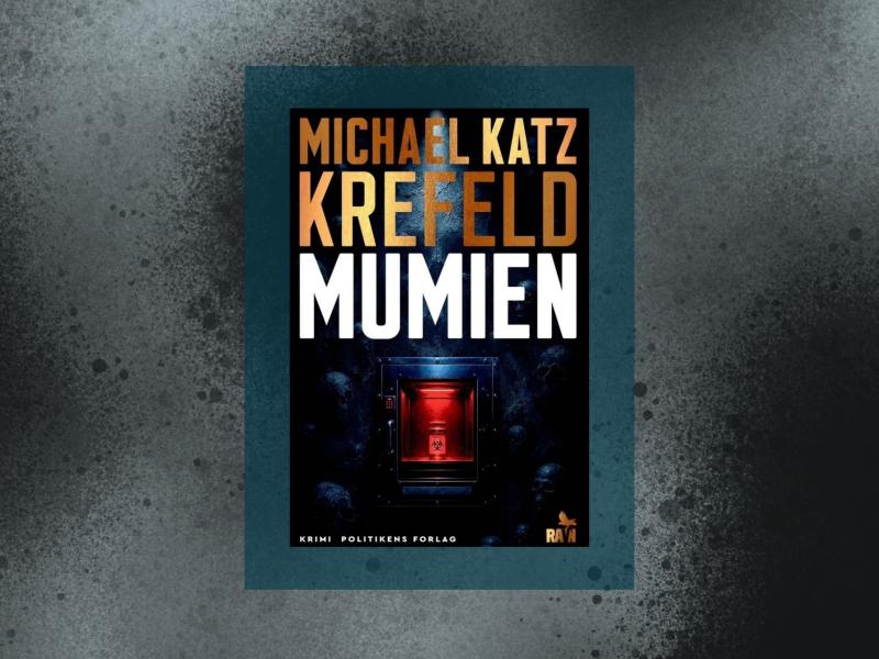 Coveret til "Mumien" indrammet af et blågrønt felt og mørke stænk.