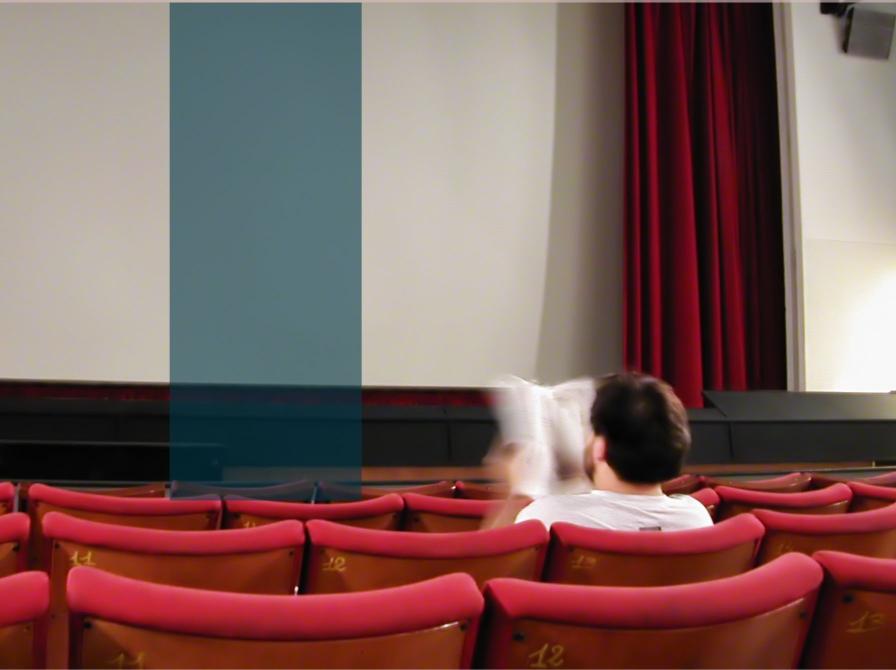 Mand læser bog i biografen